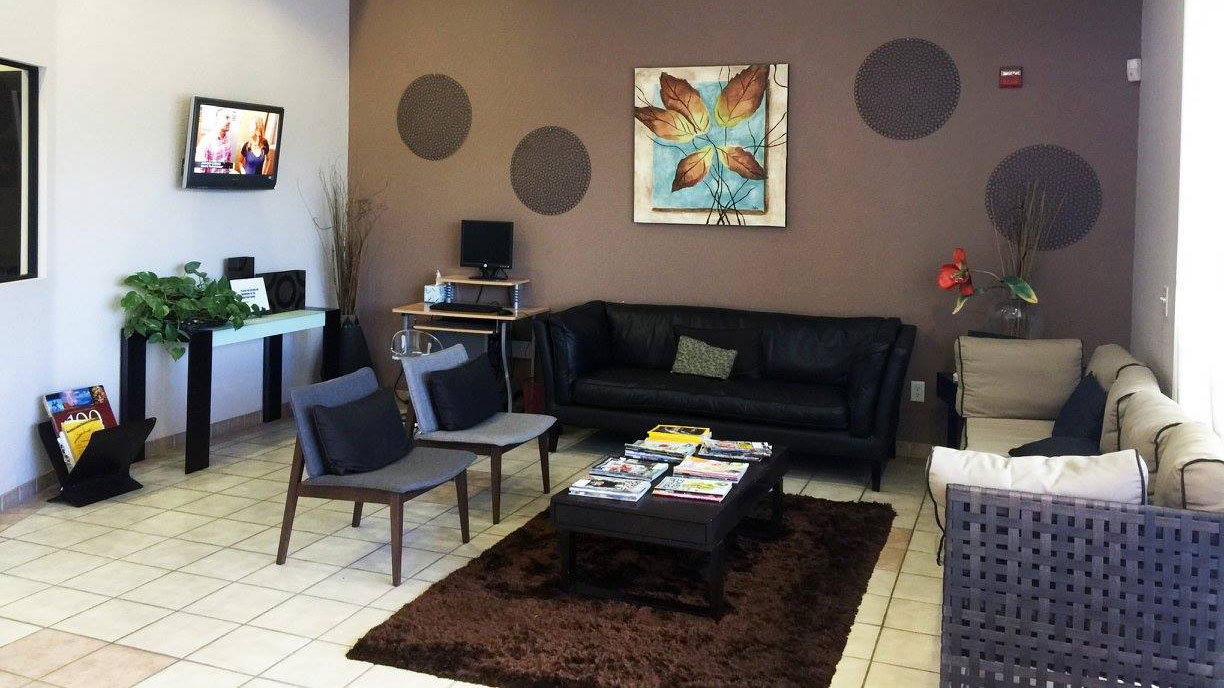 The image shows a modern dental clinic interior with various pieces of equipment, including a dental chair and an X-ray machine.