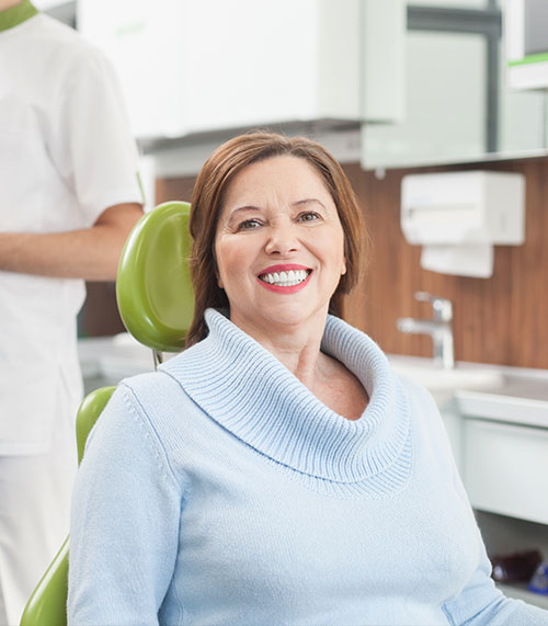 This image shows a medical device, possibly an ultrasound machine or similar equipment, placed on a table next to a laptop with a screen displaying what appears to be an ultrasound image. To the right of the table is a metal toolbox, and in front of it is a small white cart with a computer monitor attached to its side. The setting suggests a medical or diagnostic environment.