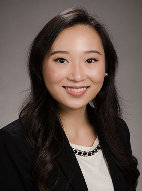 A woman in a business suit posing for a portrait with a smile.